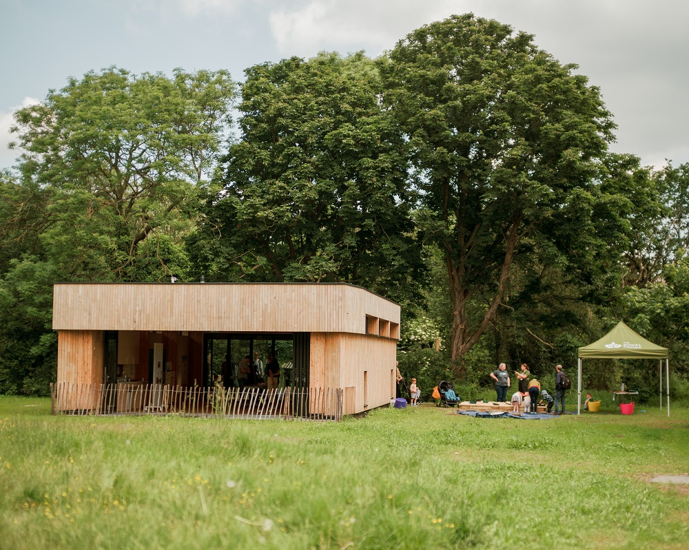 A view of the new Greenwich Park Learning Centre with a Royal Parks gazebo set up to the right of it. 