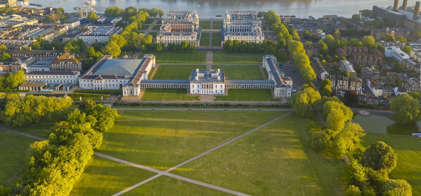 An aerial view of Greenwich Park and the Queen's House looking toward the River Thames and Canary Wharf