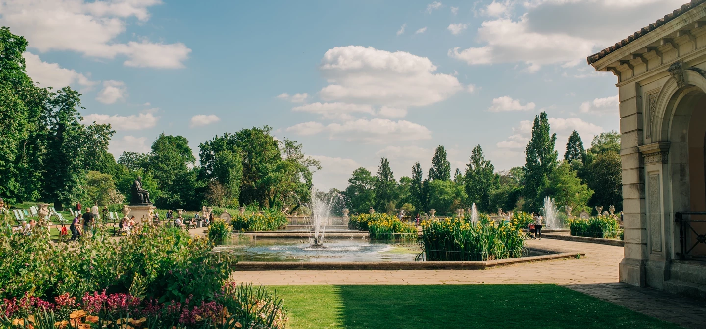 Landscape image of a garden with a fountain in between