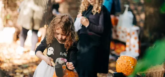 Children pumpkin carving in Halloween themed activities