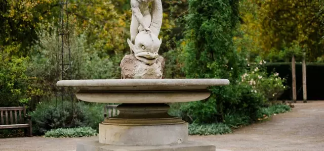 Boy and Dolphin Fountain statue in the Hyde Park rose garden in autumn