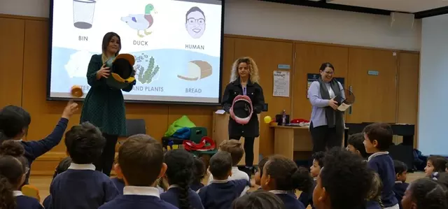 School children playing an educational game in assembly