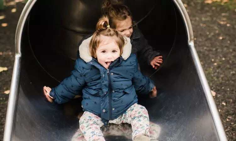 Toddlers enjoying a slide