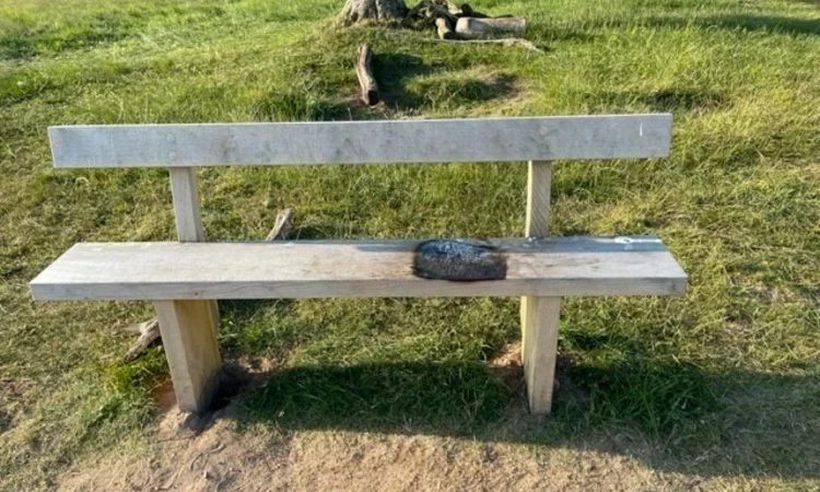 Park bench burnt by a portable barbecue