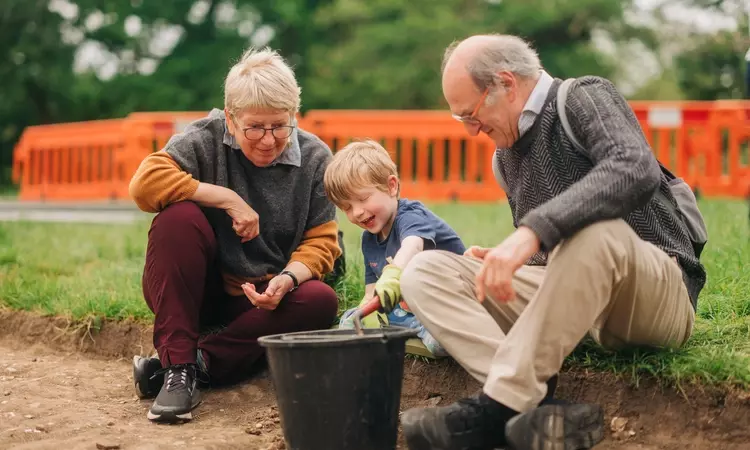 A small child looks at archaeological finds with his grandparents