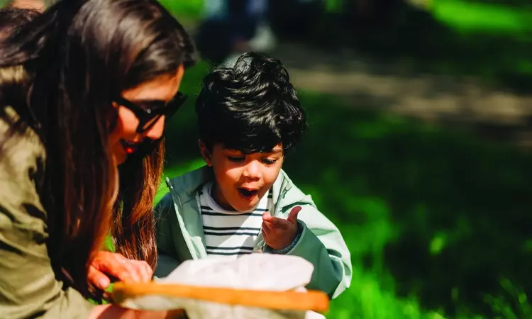 Parent and young boy looking at something in child's hand