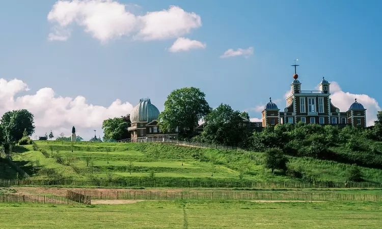 A view of the grand ascent in Greenwich Park on a sunny day with the Royal Observatory in the background. 