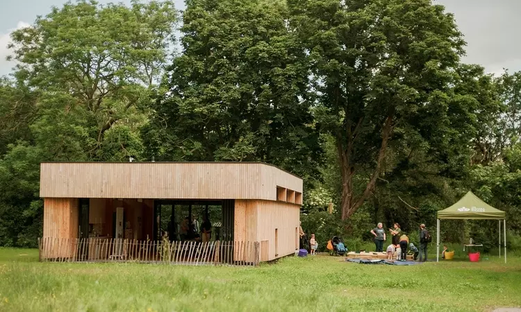 A view of the new Greenwich Park Learning Centre with a Royal Parks gazebo set up to the right of it. 