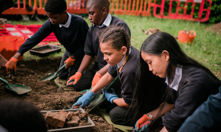 A group of children join in an archaeological dig