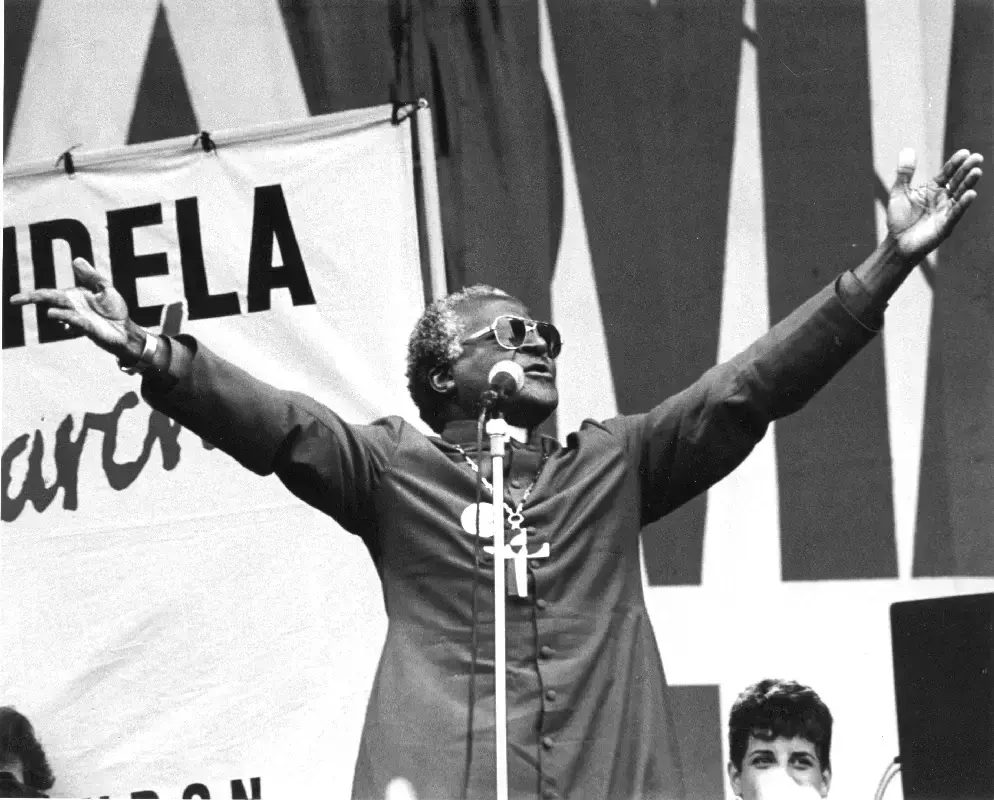 Bishop Desmond Tutu speaking in front of the crowd in Hyde Park at the 'Nelson Mandela: Freedom at 70' concert and rally, 1988