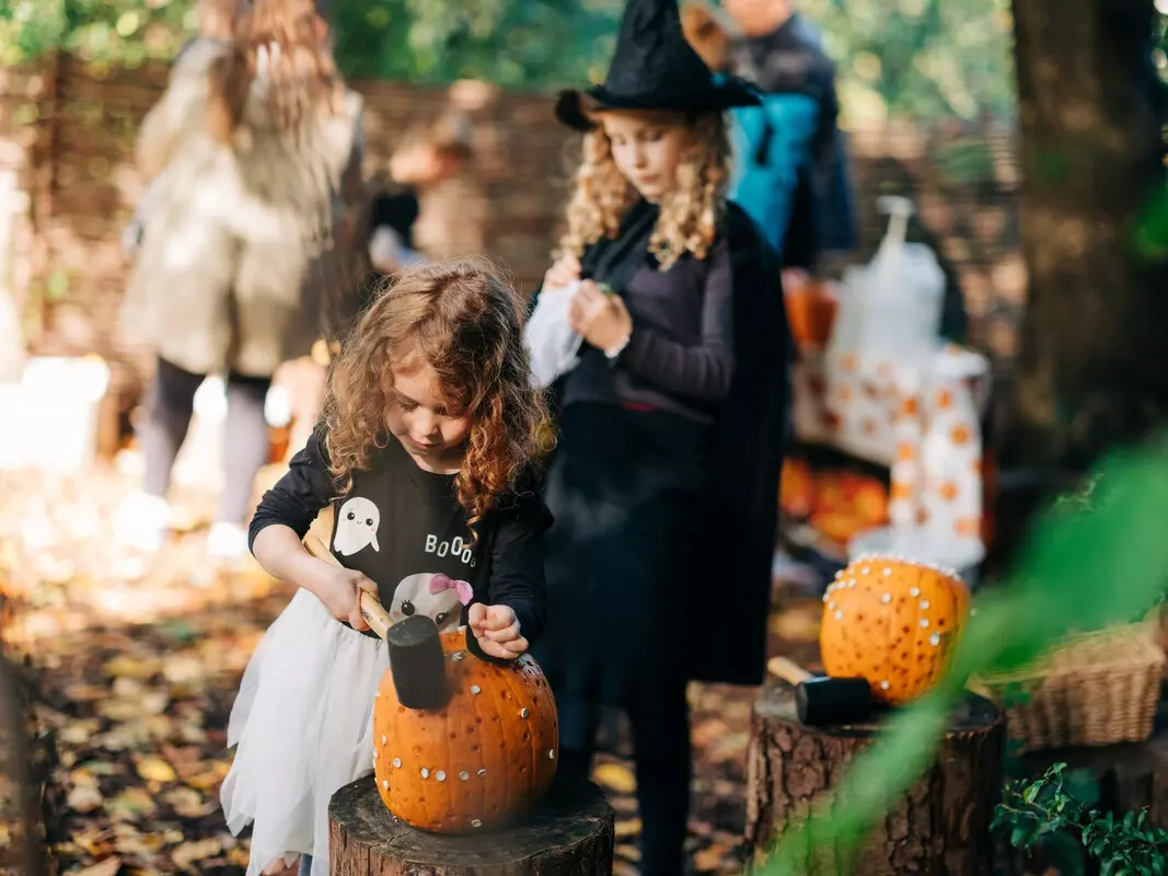 Children pumpkin carving in Halloween themed activities