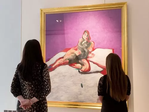 Two people looking at a Francis Bacon painting of Henrietta Moraes sold to an anonymous buyer in 2012 for £21.3 million