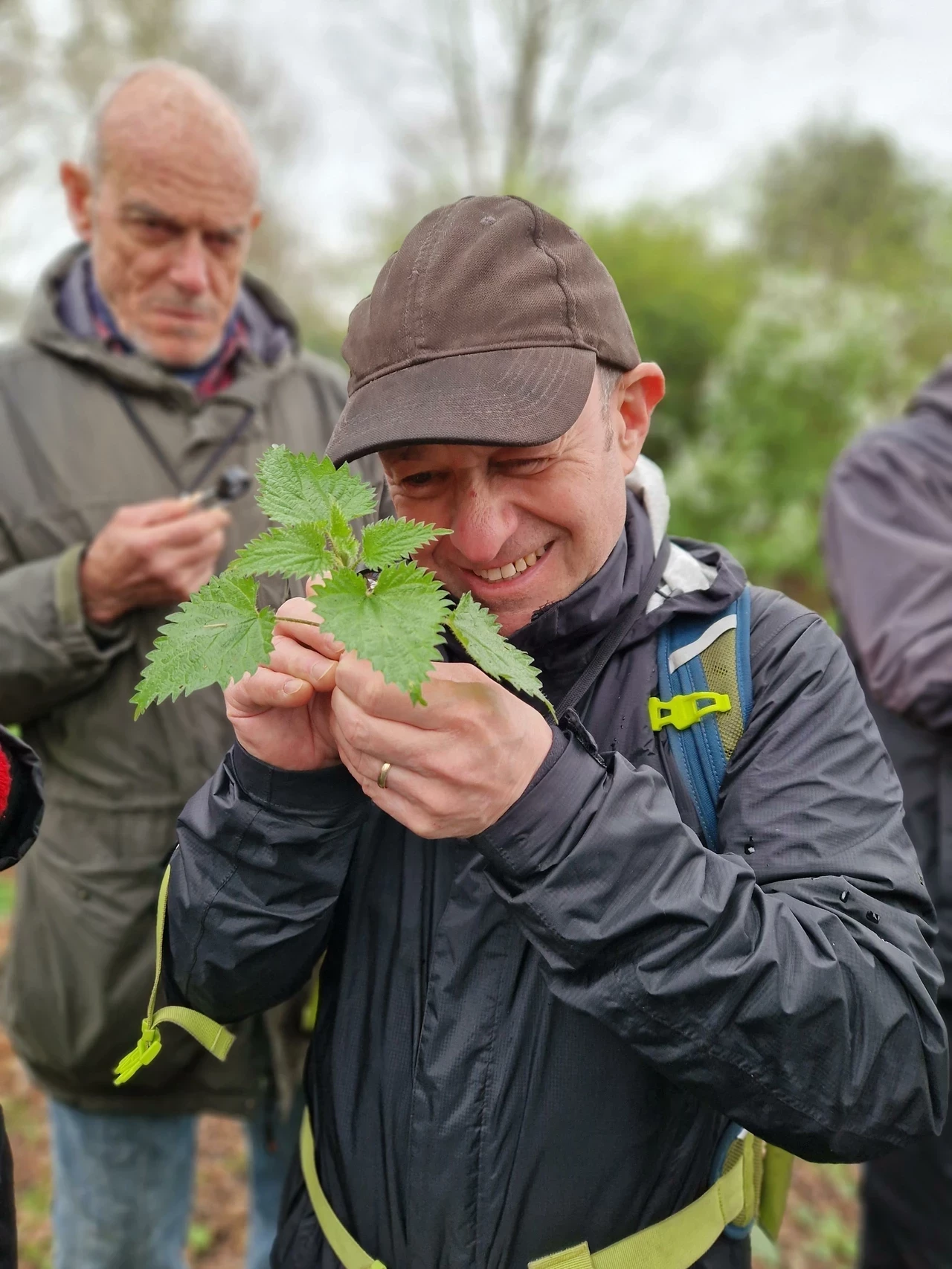 Man looking at a weed with a magnifying lens