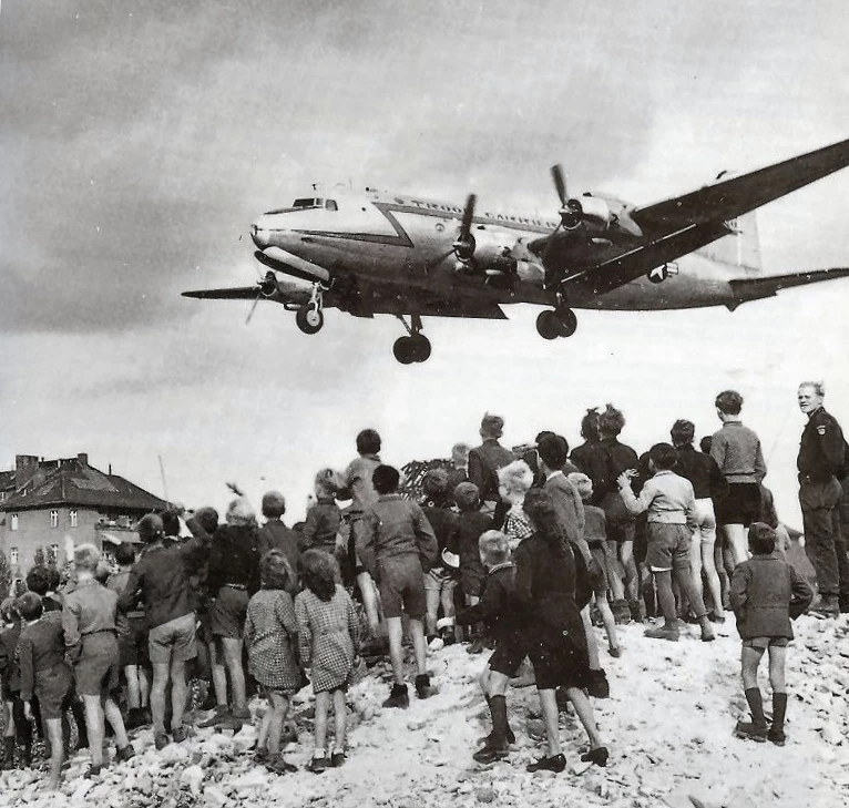 People in Berlin watching a C-54 aircraft land at Berlin Tempelhof Airport, 1948