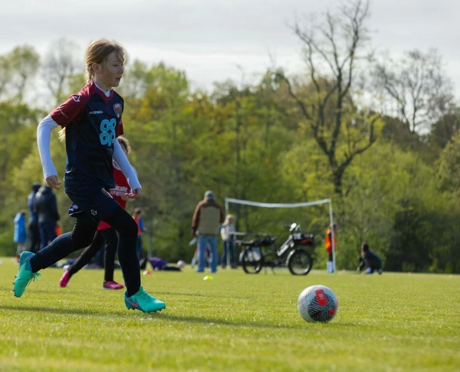 A young girl playing football