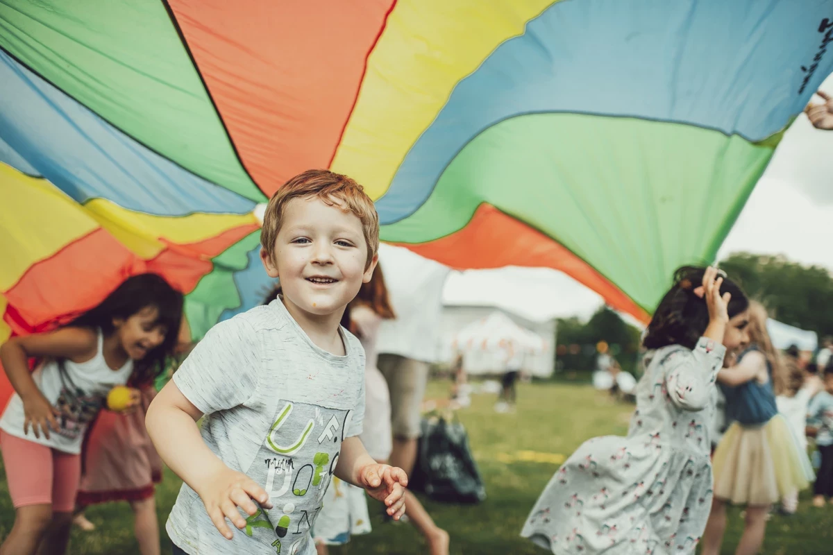 Young children playing with a play parachute