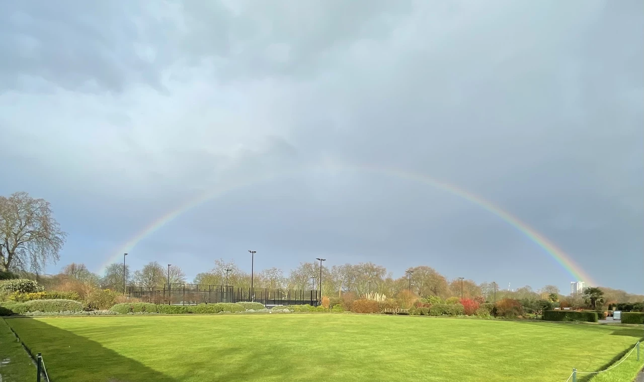 A rainbow over a bowling green in a park