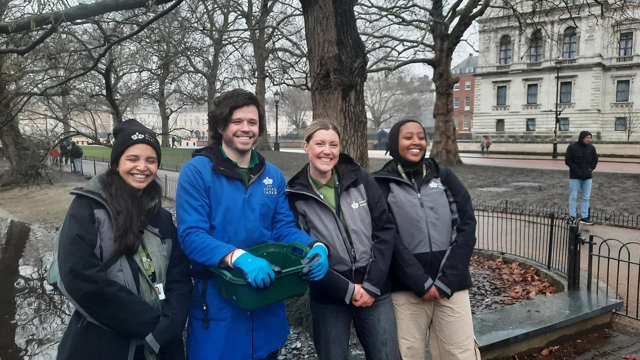 Four people smiling by the lake in St. James's Park